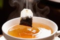 Steaming cup of tea with floating teabag infusing rich flavors Royalty Free Stock Photo