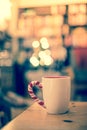 Steaming cup of thee on a wooden table, christmas time, blurry background