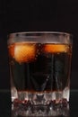 A steaming glass of cold thirst-quenching red-brown drink with ice cubes Royalty Free Stock Photo