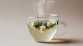 Steaming herbal tea in glass cup with assorted flower blossoms Royalty Free Stock Photo
