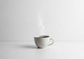 With steaming hot coffee on a smooth, white surface against a white Royalty Free Stock Photo
