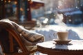 Steaming hot cup of coffee on wooden table of beautiful snow covered typical Parisian cafe in France. Sunny cold day on winter