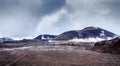 Steaming lava valley with volcanoes craters in the background