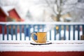 steaming mug of cocoa on snow-covered picnic table Royalty Free Stock Photo