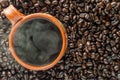 Steaming mug of Mexican coffee and dark roasted coffee beans