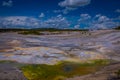 Steaming opaque thermal pools at Norris Geyser Basin. Yellowstone National Park, Wyoming, in beautiful blue sky and Royalty Free Stock Photo