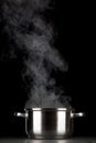 Steaming pot on black background Royalty Free Stock Photo