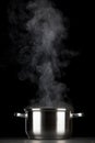 Steaming pot on black background Royalty Free Stock Photo