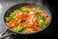 Steaming vegetable curry with chickpeas, broccoli and red bell pepper in coconut milk in a cooking pan on a black stove, healthy