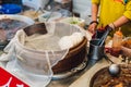 Steaming white bun in bamboo basket with warm braised pork belly in pan for making Pork Belly Bun Gua Bao in street food market.