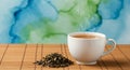 A steaming white ceramic cup filled with tea sits on a bamboo mat. Beside the cup is Royalty Free Stock Photo