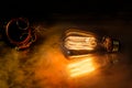 A steampunk scene with a victorian feel, bathed in warm orange light produced by the edison style lightbulb Royalty Free Stock Photo