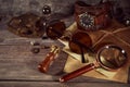 Steampunk still life - old vintage objects on a wooden background. Leather wrist watch, dark glasses, old tube lamps, magnifying g