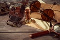 Steampunk still life - old vintage objects on a wooden background. Leather wrist watch, dark glasses, old tube lamps, magnifying g