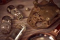 Steampunk still life - old vintage objects on a wooden background. Leather wrist watch, dark glasses, old tube lamps, magnifying g