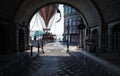 Steampunk style city streets with a view through a tunnel and a airship steam powered hot air balloon in the background .