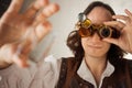 Steampunk style researcher mechanist of the monocle with a large number of lenses looking at something
