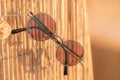 Steampunk sunglasses model with round lenses hanging on a bamboo fence in a summer day closeup. Selective focus