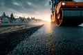 Steamroller flattening fresh asphalt on a road construction site at sunset Royalty Free Stock Photo