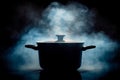 Steamy mystery Pot emitting steam, dark logo, saucepan in shadows