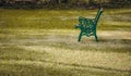 A steel bench in a green grass field. Empty chair in a park Royalty Free Stock Photo