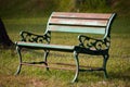 A steel bench in a green grass field. Empty chair in a park. Focus set of chair grill Royalty Free Stock Photo