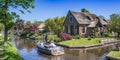 Steel boat passing by the old houses in the center of Giethoorn