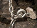 Steel bolt anchor eye in hard basalt rock. End of steel chain Royalty Free Stock Photo