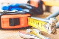 Steel bolt nuts and washers lie on wooden boards near an adjustable spanner and a tape measure Royalty Free Stock Photo