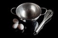 Steel bowl whisker eggs high angle with reflection on black