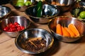 Steel bowls with raw ingredients for cooking at a culinary master class, bowl with cherry tomatoes, peeled carrots, cinnamon