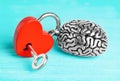 Steel brain attached to a heart-shaped padlock Royalty Free Stock Photo