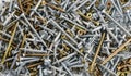 Steel and brass screws and metal dowels scattered on flat surface Royalty Free Stock Photo
