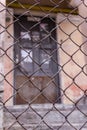 Steel chain link or wire mesh as boundary wall. There is door behind the mesh.