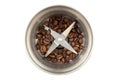 Steel coffee grinder with a small amount of coffee beans isolated on white background Royalty Free Stock Photo