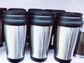 Steel coffee mugs kept in a row in crockery store. Tea mugs (cups) set arranged in a line in a shop closeup image photo.