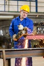 Steel construction worker cutting metal with angle grinder Royalty Free Stock Photo