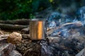 Steel cup on an open fire in nature