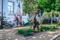 Steel dinosaur on a flowerbed near the colorful facade of a kindergarten on Kanatna Street in
