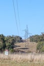 Steel electricity tower with low hanging wires and danger sign