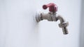 A steel faucet and red handle with white wall Royalty Free Stock Photo