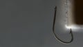 A steel fishhook is stuck into a glowing object. Royalty Free Stock Photo