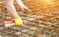 Steel fixer assembling reinforcement cage off rebars. Selective focus Royalty Free Stock Photo