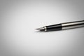 Steel fountain pen on a sheet of white paper. Royalty Free Stock Photo