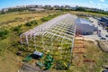 Steel frame construction of modern storage warehouse building at big city suburb. Aerial drone view from above