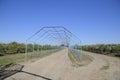 Steel gazebo for grapes over the road in the apple orchard. Fruit garden Royalty Free Stock Photo