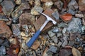 Steel geologist rock pick over brown and grey rocks in chromite mining area in Troodos mountains, Cyprus