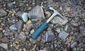 Steel geologists rock pick over background of multicolored serpentine rocks