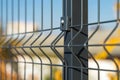 Steel grating fence made with wire on blue sky background. Sectional fencing installation.