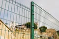 Steel grating fence made with wire on old building background. Sectional fencing installation.